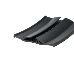 Close-up of a black curved plastic strip with ridged edges and a hollow channel