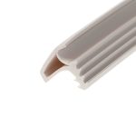 Close-up of a white plastic object with curved edge and multiple parallel grooves or slots, photographed at an angle.