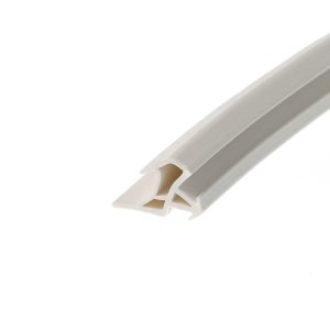 Close-up of a white plastic track or extrusion with a beige interior, photographed at a diagonal angle