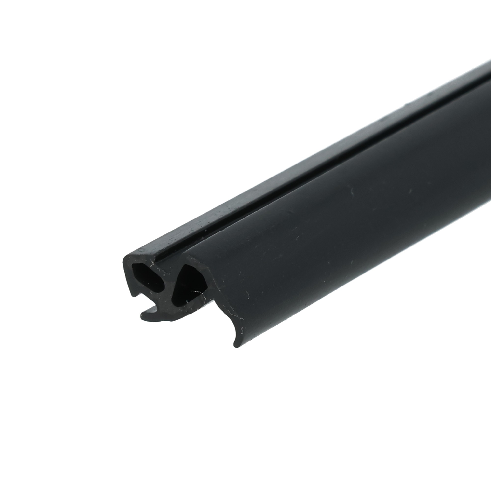 uszczelka-do-okien-pcv-czarna-s-1559-12-809-3 - Centrum uszczelek Close-up of a black metal extrusion with a serrated U-shaped end against a white background, diagonally oriented across the frame.