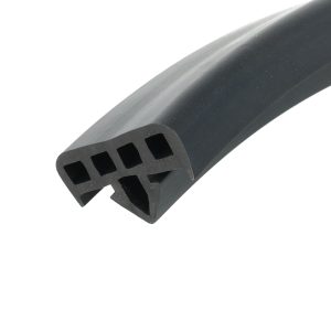 Close-up of a black plastic component with rectangular square-shaped openings along its curved surface, photographed diagonally.