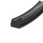 Close-up of a black foam seal or gasket with a hollow, porous interior and curved extrusion.