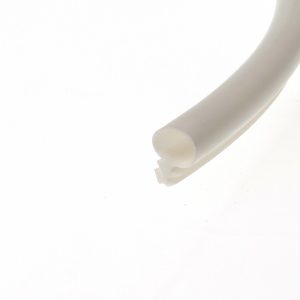 Close-up of a white curved cylindrical object against a pale background, with soft shading on the right edge.