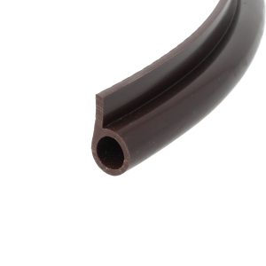 Close-up of a curved dark chocolate piece with a square cross-section and a hollow circular channel at the end.