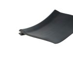 Close-up of the curved edge of a dark, matte surface against a white background.