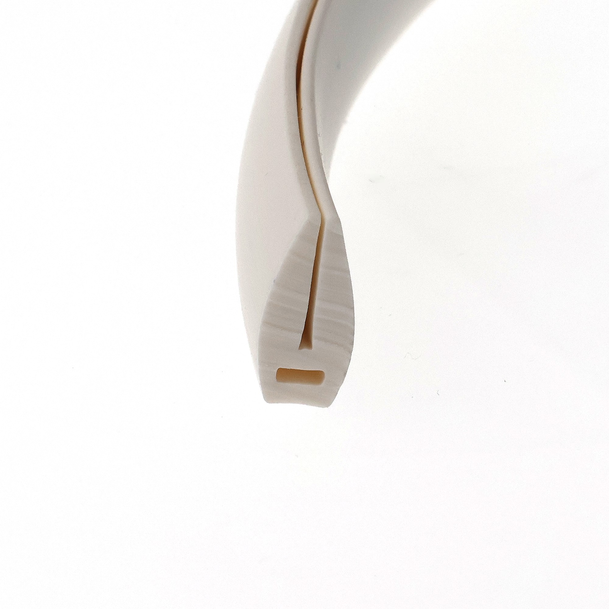 uszczelka-krawedziowa-miekkie-pvc-1-16-x-7-x-15mm-biala-12-322-3 - Centrum uszczelek Close-up of a white curved ceramic surface with a brown edge against a white background.