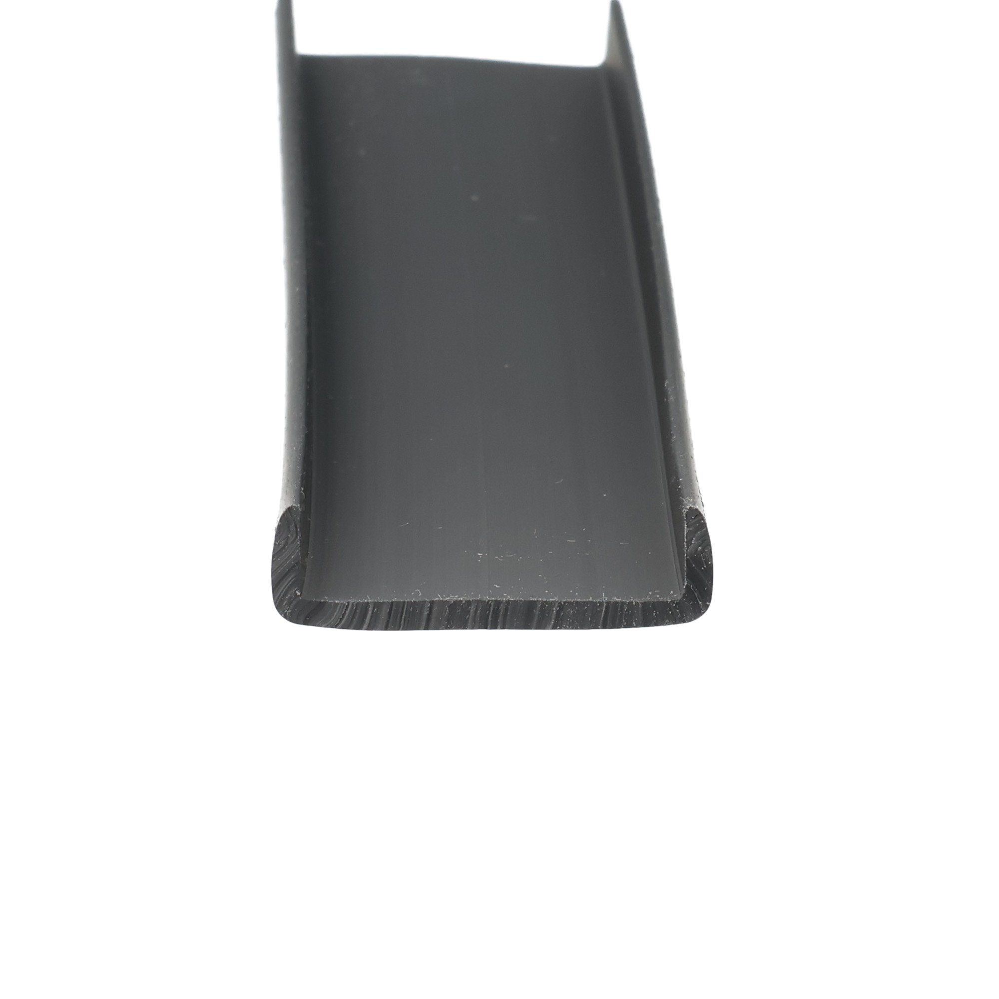 uszczelka-krawedziowa-miekkie-pvc-25-x-8-x-29mm-czarna-12-315-03-3 - Centrum uszczelek Close-up of a black plastic edge with a rounded bottom corner, shown from the side (part of a larger tool).