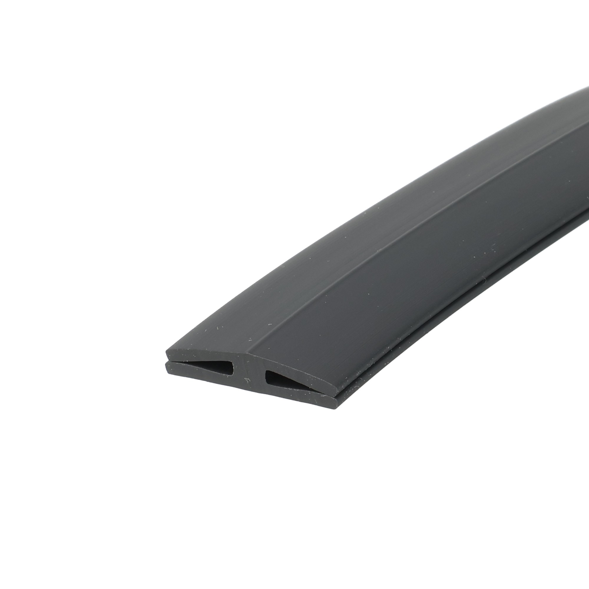 uszczelka-krawedziowa-szyby-plyty-poliweglanowej-typ-h-miekkie-pvc-h-1-2-x-5-x-24-mm-czarna-12-841-2 - Centrum uszczelek Close-up of a gray U-shaped plastic extrusion with hollow rectangular openings along the edge, diagonally oriented across a white background.