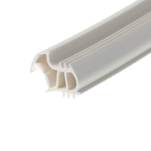 Close-up of a white plastic cable raceway or conduit with internal slots for organizing wires, photographed at an angle.