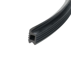 Close-up of a black rubber weatherstrip with ribbed surface and hollow channel, curved along the edge.