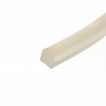 Close-up of a beige plastic corner or edge of a rectangular object set against a white background, oriented diagonally across the image.