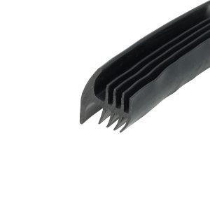 Close-up of a black plastic object with several parallel teeth, like a comb, diagonally placed against a white background.