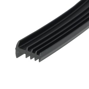 Close-up of a black, ribbed plastic extrusion with multiple grooves along a diagonal edge.