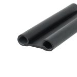 Close-up of black foam pipe insulation cylinders with hollow cores showing a textured surface.