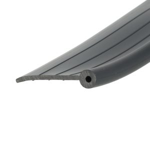 Close-up of a grey, ridged plastic or metal edge running diagonally across the image, with a rounded end and a circular hole visible.