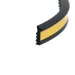 Close-up of a black curved foam strip with a yellow edge stripe, showing its cross-section.