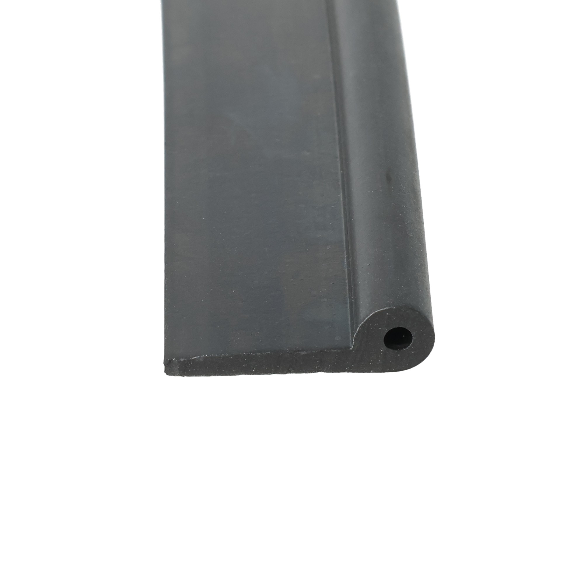 uszczelka-drzwi-gumowa-typ-p-2-x-6-x-21mm-czarna-046819-1 - Centrum uszczelek Close-up of a dark gray curved-edged component with a circular hole near the bottom-right corner, taken from the edge.