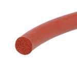 Close-up of a red foam cylinder cut to show its porous interior surface, viewed from the end.