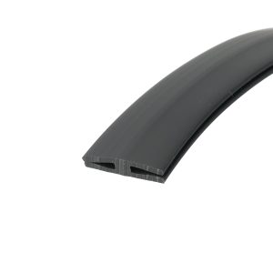 Close-up of dark rubber weatherstripping with a hollow U-shaped channel, curved edge visible at bottom-right.