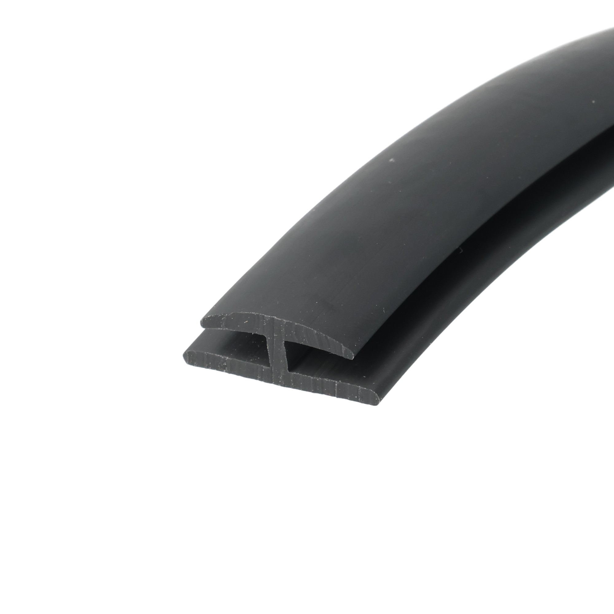 uszczelka-krawedziowa-typ-h-miekkie-pvc-4-x-20-x-27mm-czarna-12-321-2 - Centrum uszczelek Close-up of a black rubber seal with a U-shaped channel, curved profile over the surface.