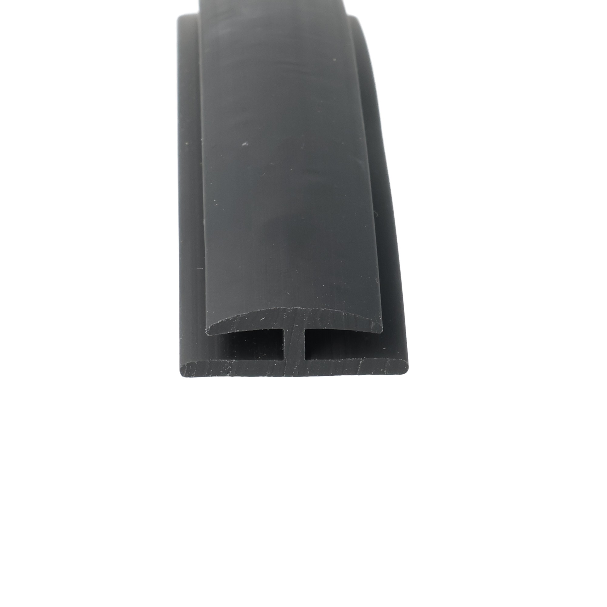 uszczelka-krawedziowa-typ-h-miekkie-pvc-4-x-20-x-27mm-czarna-12-321-3 - Centrum uszczelek Close-up of a dark plastic object with a small rectangular slot at the bottom.