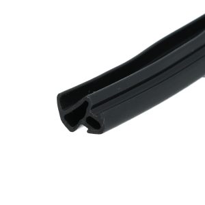 Close-up of a black hollow plastic tube with two round openings and an elongated slot along its side, angled diagonally across the frame.