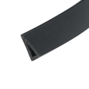 Close-up of a black rectangular object with a beveled edge on a white background, angled across the frame.