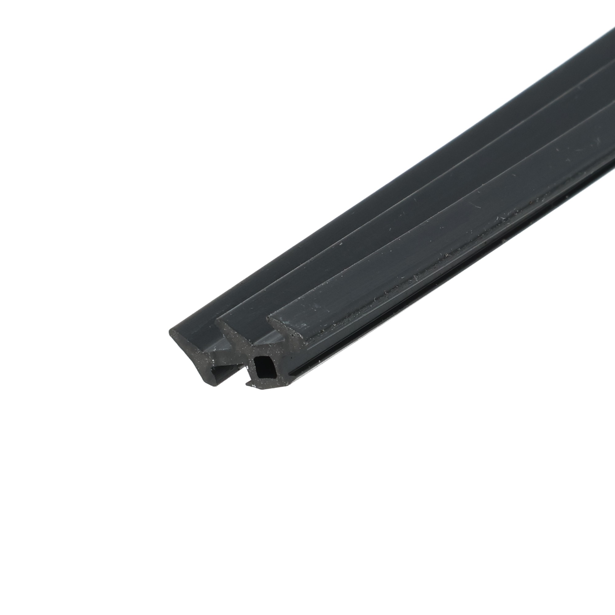 uszczelka-okna-pvc-i-alu-gumowa-lita-czarna-0357351-1 - Centrum uszczelek Close-up of a black grooved rail or track piece diagonal across a white background