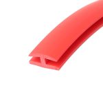 Close-up of red plastic extrusion with a curved edge and hollow cross-section, showing interlocking notches at the end.