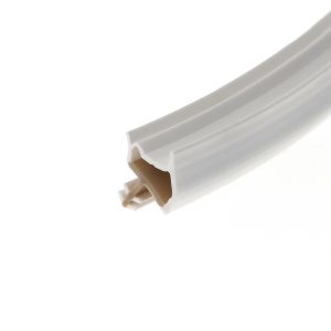 Close-up of a white plastic channel with beige interior fins, diagonally across the lower-right corner.
