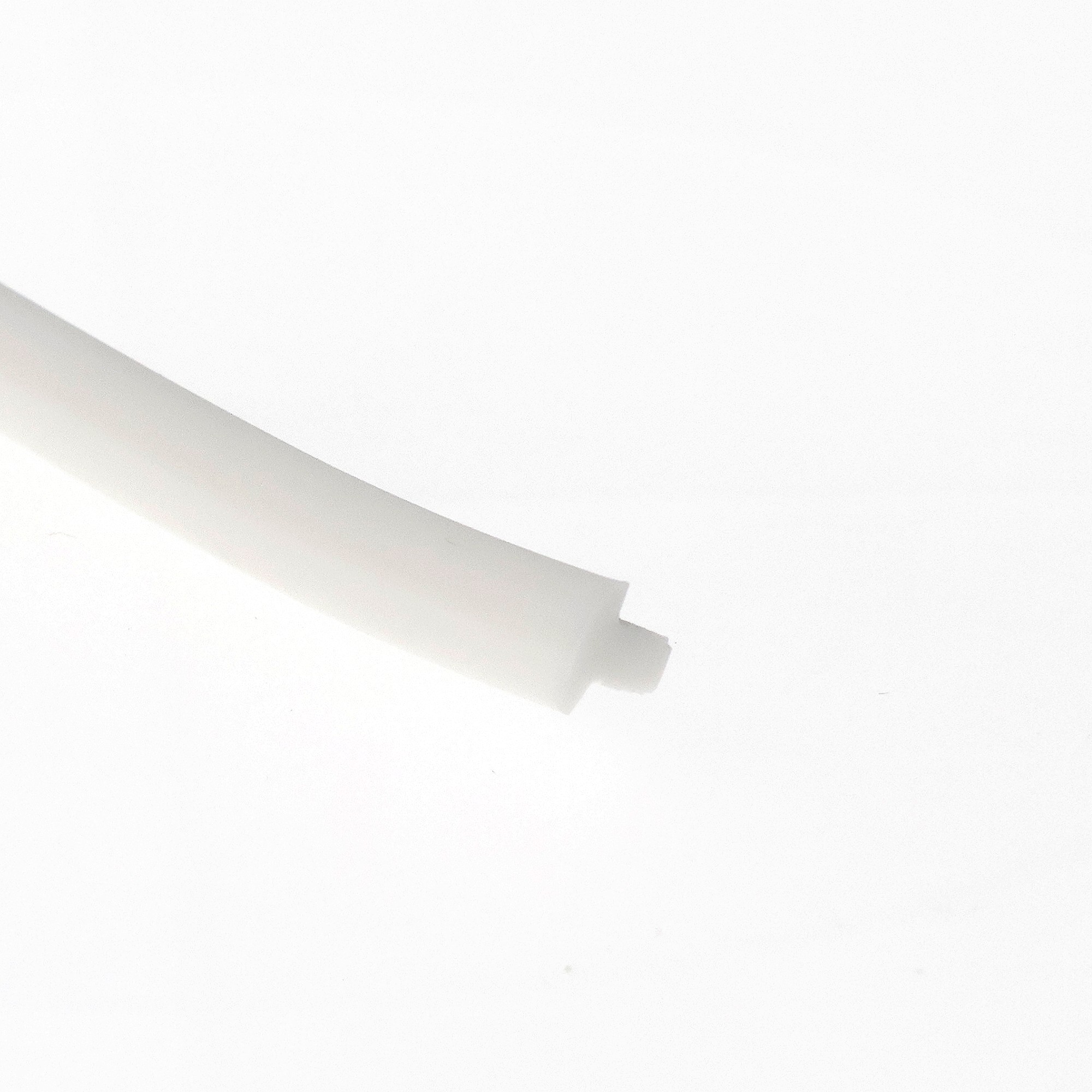 uszczelka-wciskana-szczelinowa-silikonowa-2-x-5-x-5mm-biala-0995462-3 - Centrum uszczelek White curved strip crossing diagonally across a pale surface, with soft shadows.