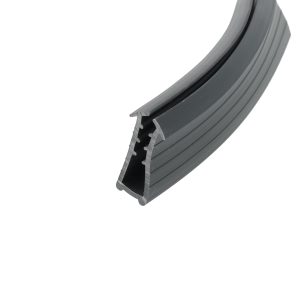 Close-up of a gray curved rubber seal with ridges and a hollow channel in the center edge.The image shows a section of weather stripping used for doors or windows (close-up).