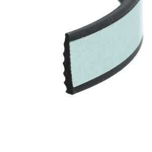 Close-up of a light blue foam sanding block edge with black abrasive grit on the border.