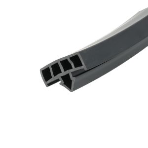 Close-up of a gray plastic extrusion with evenly spaced rectangular slots along the edge.