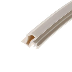 Close-up of a white molded plastic piece with grooves, oriented diagonally against a white background.