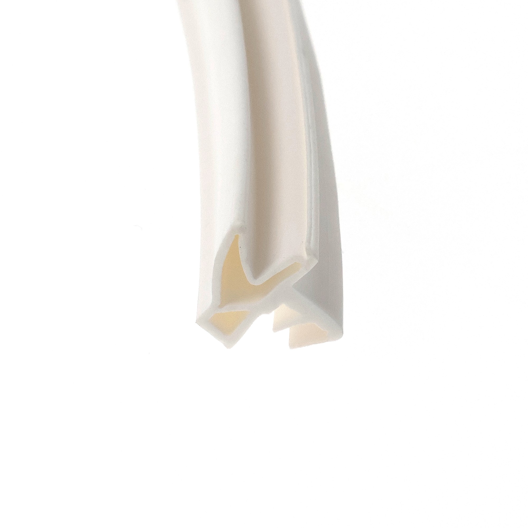 uszczelka-drzwi-wewnetrznych-drewnianych-s-6577-devneter-biala-070-098-2 - Centrum uszczelek Close-up of a pale beige curved object with masking tape pieces on a white background, abstract detail.