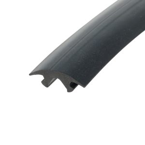 Close-up of a dark, slightly curved blade or edge running diagonally across a white background, showing a bevelled edge and small surface specks.
