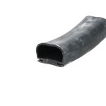 Close-up of a curved black rubber extrusion with a hollow rectangular opening, showing a worn dusty surface.