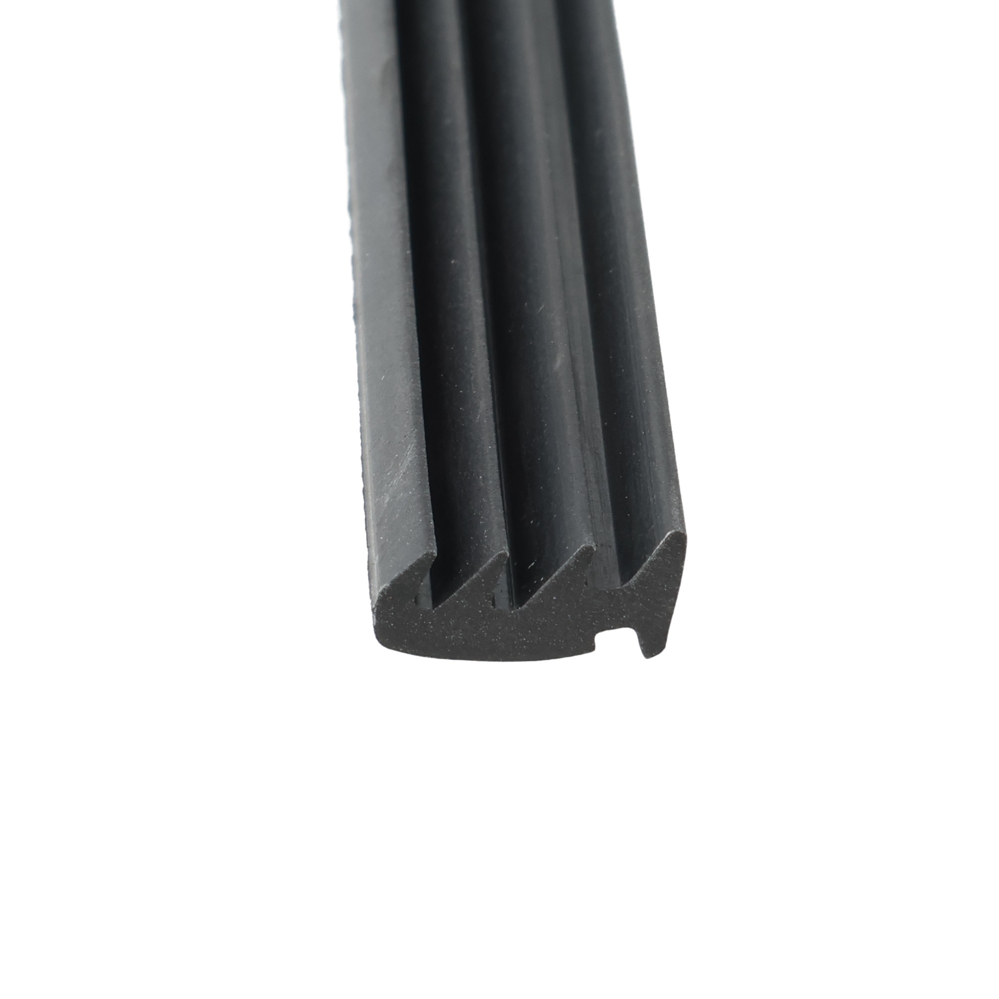 uszczelka-do-okna-na-profilu-alumniowym-lub-pvc-gumowa-czarna-0351007-2 - Centrum uszczelek Close-up of three dark rubber strips standing side by side, showing their curved surfaces and ridged bottom edge.
