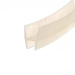 Abstract close-up of pale beige masking tape diagonally across a white background, showing layered edges and soft shadows from the folds.