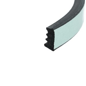Close-up of a light blue foam sanding block edge with a black abrasive strip showing the foam core.